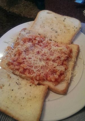A picture of Eggy bread with beans an cheese.