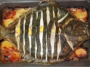 Una foto de rodaballo al horno con cebolla
