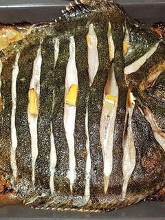 Una foto de Rodaballo salvaje al horno con guarnición de patatas y cebolla