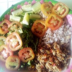 A picture of Rice and beans with vegetables and fish sauce.