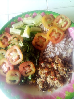 A picture of Rice and beans with vegetables and fish sauce.