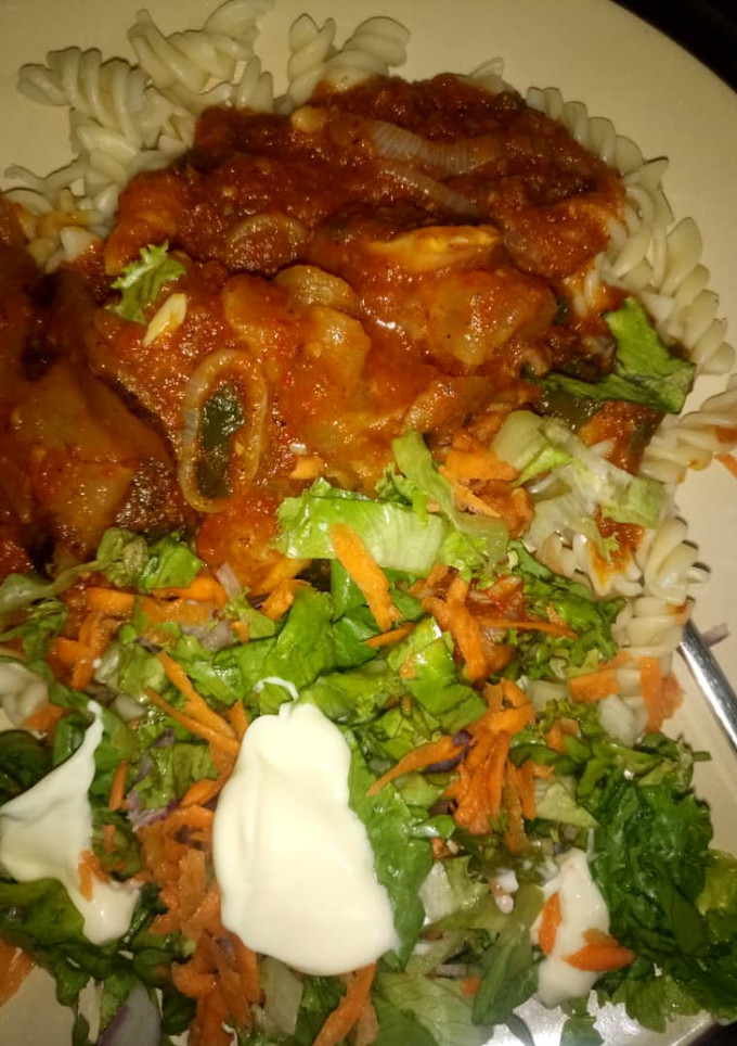 A picture of Macroni c hicken souce with salad.