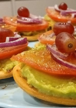 Una foto de Galletas Saladas con Guacamole, Tomate y Uva