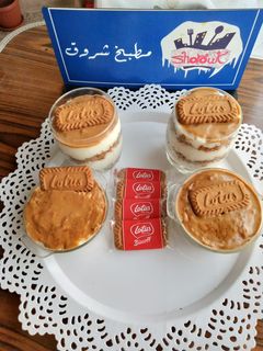 صورة لوصفة طبقات من رز بلبن و كنافه بزبدة اللوتس و صوص اللوتس على الوجه.قنبله