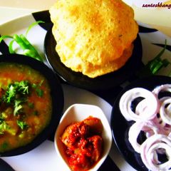 A picture of Kachori Alloo subji with curd onion rings.