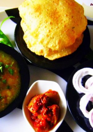 A picture of Kachori Alloo subji with curd onion rings.