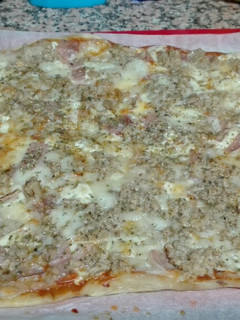 Una foto de Pizza de masa fina con atún y york