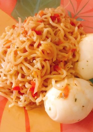 A picture of Jollof noodles and boiled egg.
