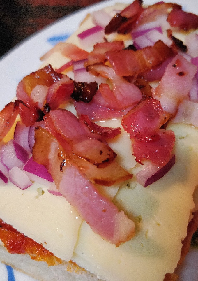 Una foto de PanPizza de bacon y cebolla
