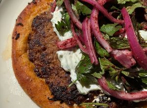 A picture of Smashed Beef Pita with Tzatziki & Sumac Salad.