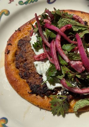 A picture of Smashed Beef Pita with Tzatziki & Sumac Salad.