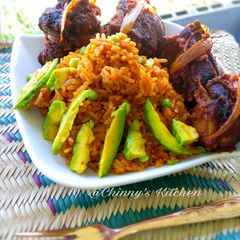 A picture of Nigeria jellof rice paired with avocado and chicken.