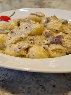 Una foto de Ñoquis en salsa cremosa de Philadelphia, champiñones y bacon