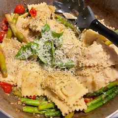 A picture of Ravioli with tomatoes and asparagus.
