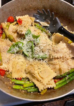 A picture of Ravioli with tomatoes and asparagus.