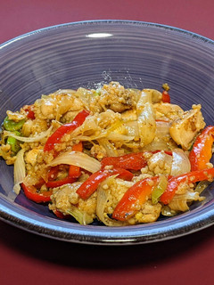 Una foto de Wok de pollo salteado con cebolla, pimiento y cous-cous
