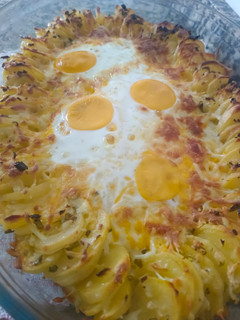 Una foto de Papas con queso y huevo al horno