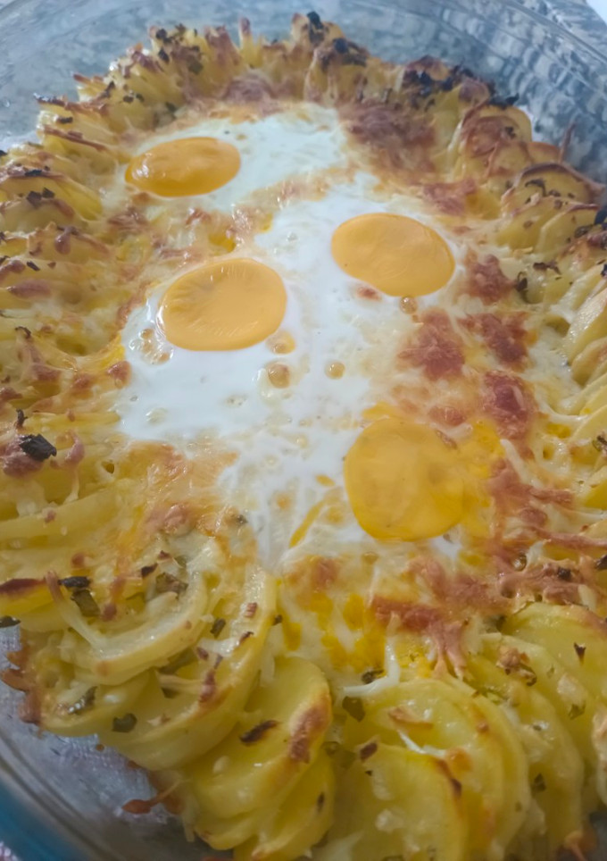 Una foto de Papas con queso y huevo al horno
