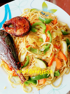 A picture of Vegetable pasta with fried fish.