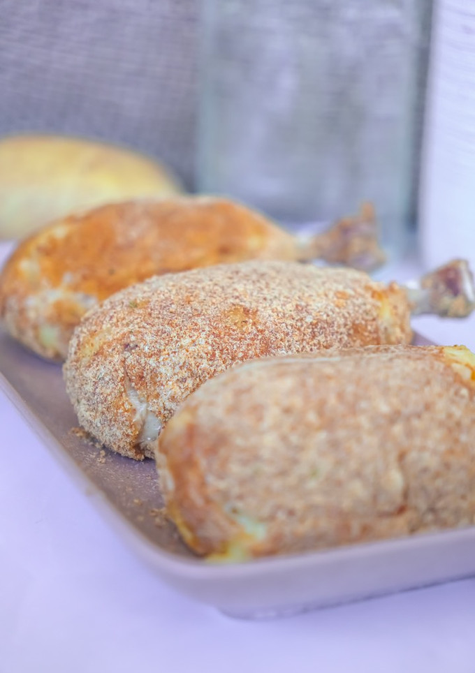 Una foto de Muslos al horno empanados con patata y queso