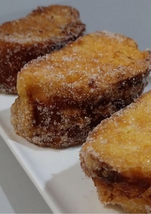 Una foto de Torrija de brioche casero bañada en crema inglesa