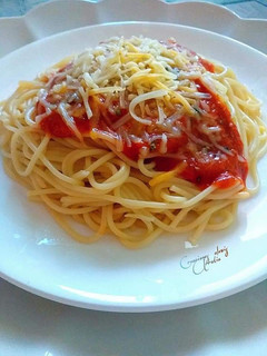 Una foto de Espaguetis en dos salsas de tomates, queso y orégano