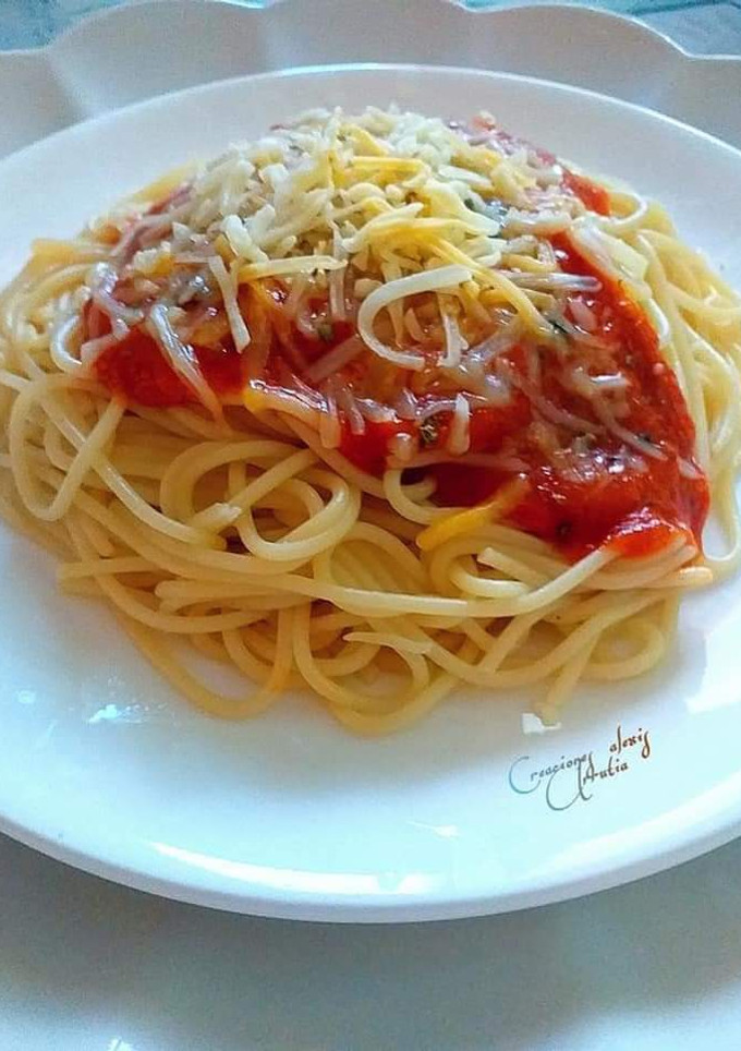 Una foto de Espaguetis en dos salsas de tomates, queso y orégano