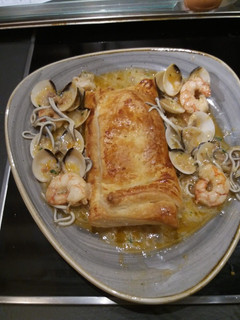 Una foto de Lomos de merluza en hojaldre con gulas almejas y gambones