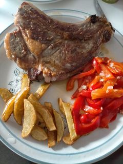 Una foto de Chuleta con patatas y pimientos