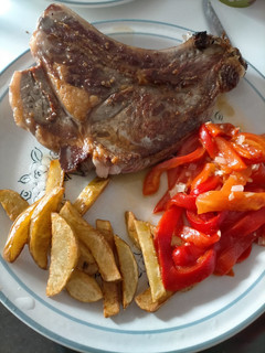 Una foto de Chuleta con patatas y pimientos