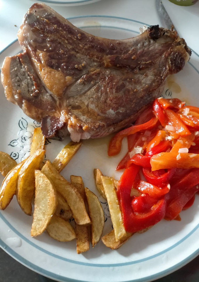 Una foto de Chuleta con patatas y pimientos