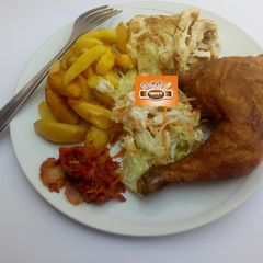 A picture of Chips, egg,salad,sauce and fried chicken.