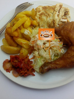 A picture of Chips, egg,salad,sauce and fried chicken.