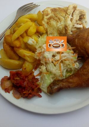A picture of Chips, egg,salad,sauce and fried chicken.