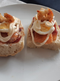 Una foto de Montadito de jamón ibérico, salmón ahumado, gamba y huevo