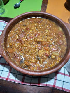 Una foto de Locro con chorizo en olla de barro