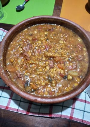 Una foto de Locro con chorizo en olla de barro