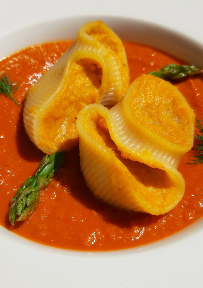 Una foto de Lumaconi rellenos de boniato y queso azul con salsa de pisto