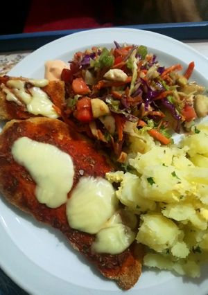 Una foto de Supremas de pollo con papas con perejil y ensalada variada