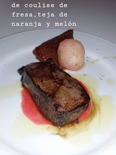 Una foto de Solomillo de corzo acompañado de coulise de fresa, teja de naranja y melón