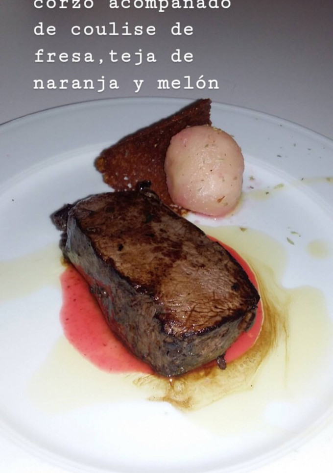 Una foto de Solomillo de corzo acompañado de coulise de fresa, teja de naranja y melón