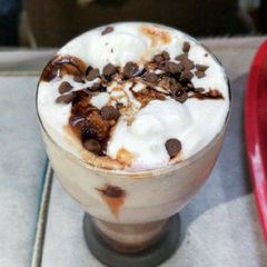 A picture of Hot chocolate milk with vanilla Ice-Cream and choco-chips on top.