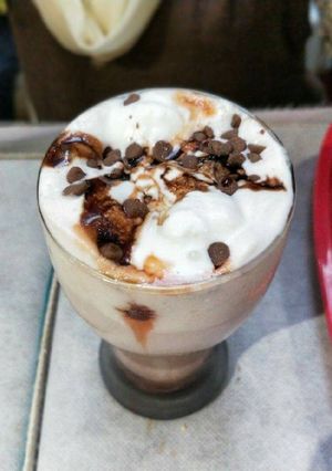 A picture of Hot chocolate milk with vanilla Ice-Cream and choco-chips on top.