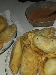 Una foto de Empanadas de carne cortada a cuchillo y salsita picante