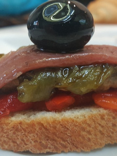 Una foto de Tostada de anchoas y pimientos rojos y verde