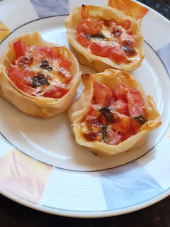 Una foto de Canastitas de tomate, queso y albahaca
