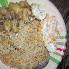 A picture of Vegetarian Jallof rice with potatoes and coleslaw.