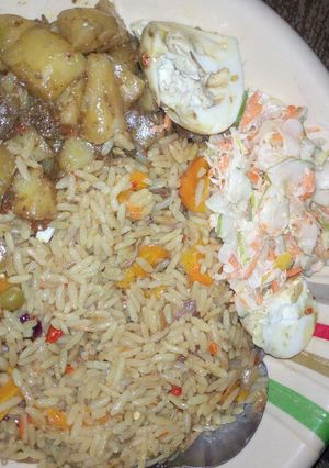A picture of Vegetarian Jallof rice with potatoes and coleslaw.