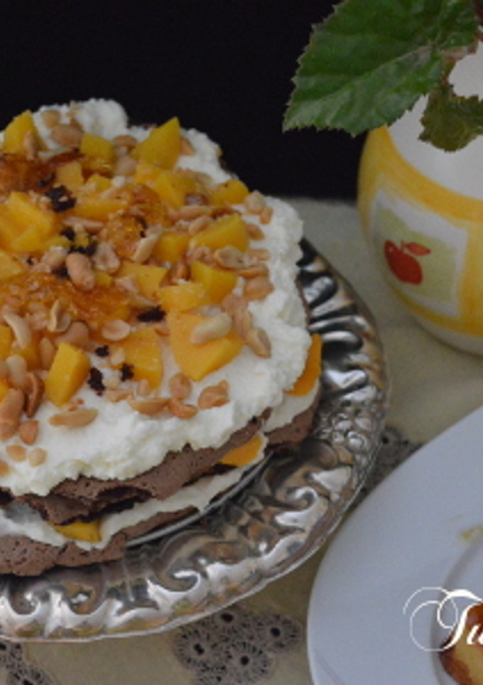 Una foto de Pavlova de Chocolate, Avellanas y Melocotón en Almíbar