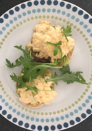 A picture of Scrambled egg and avocado on English muffin.